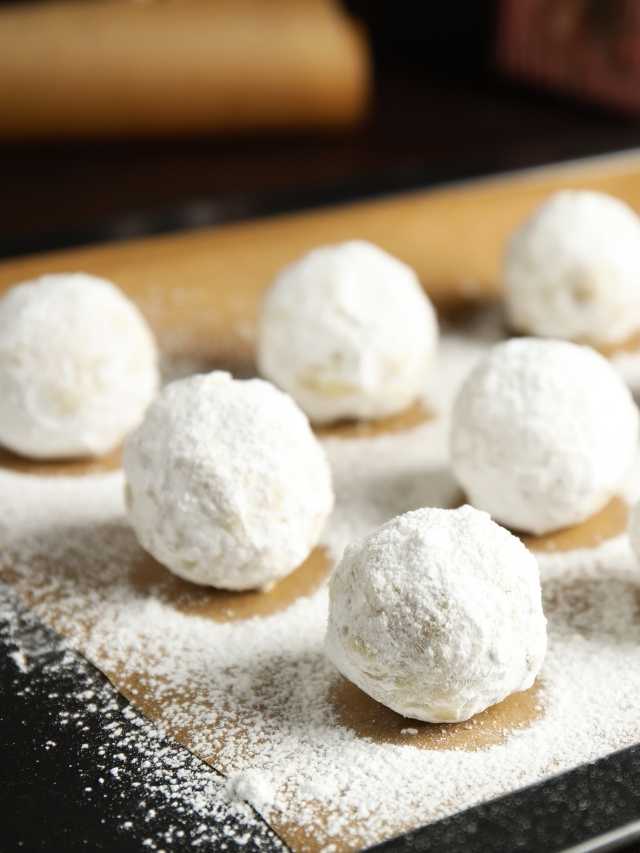White powdered sugar balls on a baking sheet.
