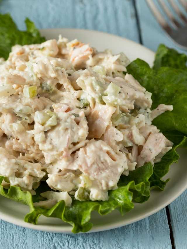 Chicken salad on a plate with lettuce and a fork.