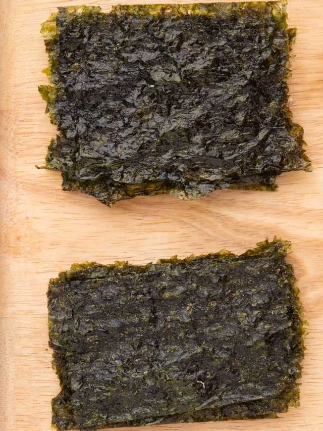 Two pieces of seaweed on a cutting board.
