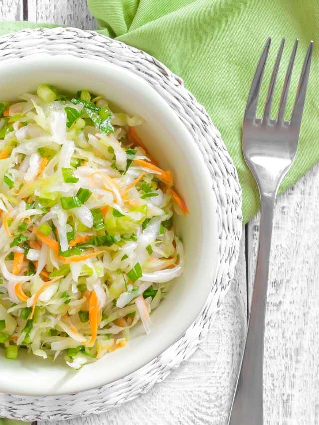 Coleslaw in a white bowl with a fork.