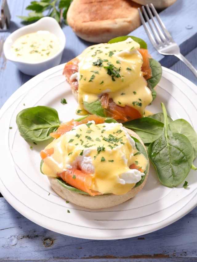 Eggs benedict with salmon and spinach on a plate.