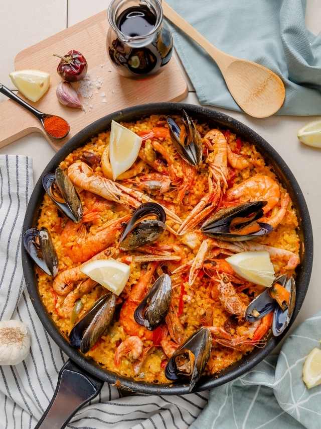 Paella with shrimp and mussels in a skillet.