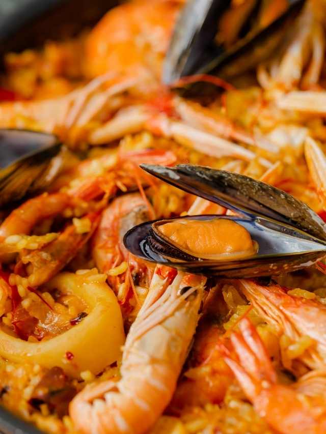 Paella with shrimp and mussels in a pan.