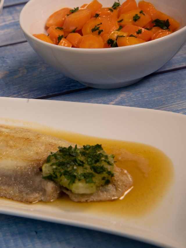 A white plate with fish and carrots on it.