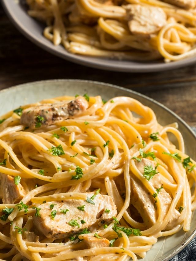 A plate of pasta with chicken and parsley, perfect to enjoy with chicken alfredo pasta.
