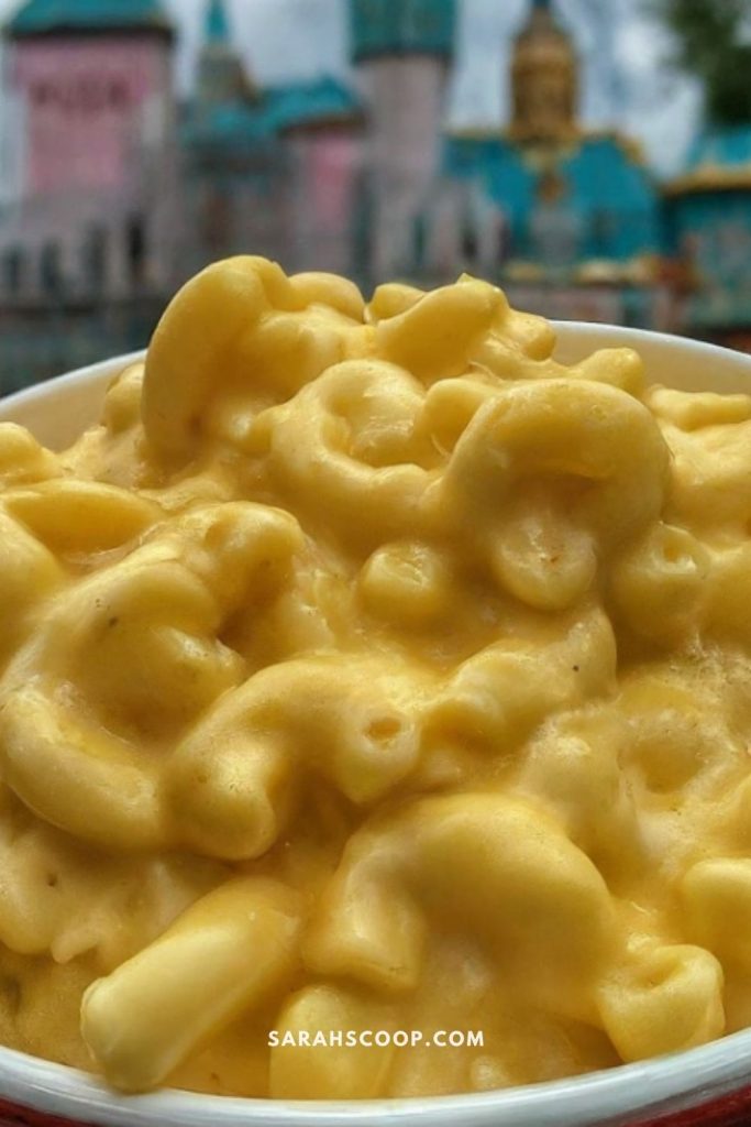 A bowl of creamy macaroni and cheese with a blurred background.