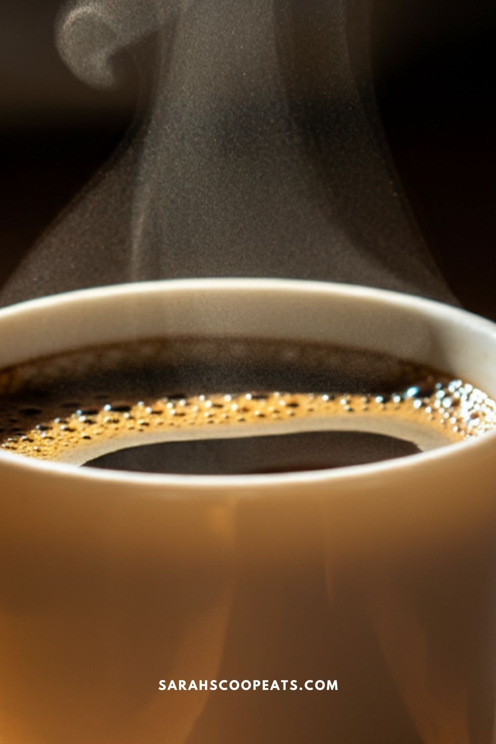 Close-up of a steaming cup of coffee in a white mug. The image includes the text "SARAHSCOOPEATS.COM" at the bottom.